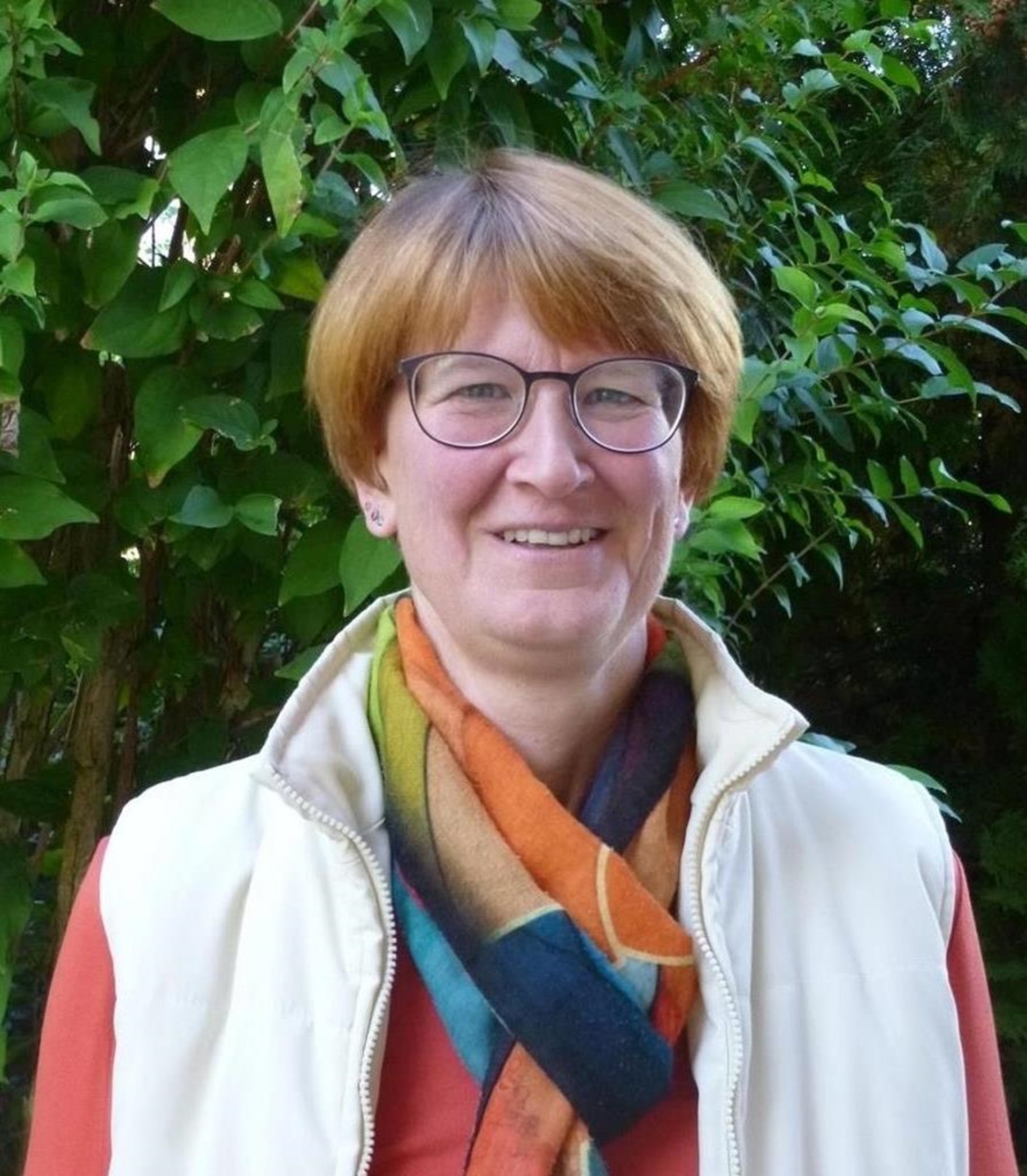 Frau vor Strauch